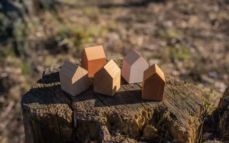 tiny wooden house models on tree stump in the outdoors