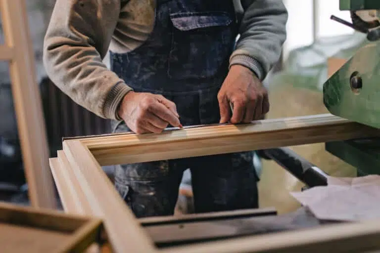 Carpenter Measuring a Wooden Plank